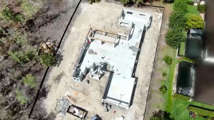Concrete block walls rising on the finished slab of a Naples custom home