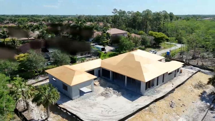 Roof trusses set and decked on a Naples custom home