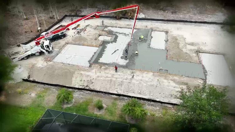 Concrete pump boom over the slab forms of a Naples custom home